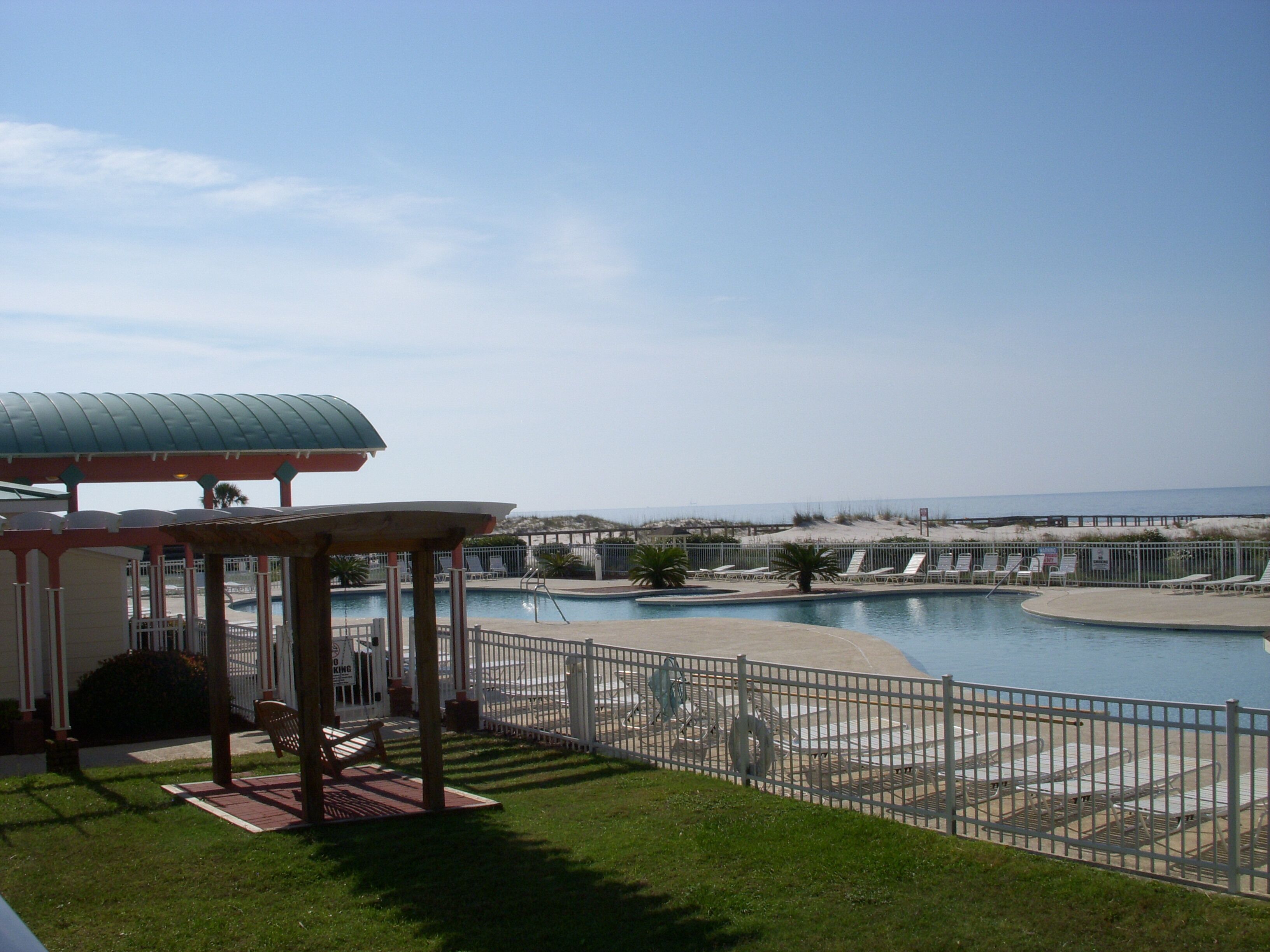 Area piscina con sedie a sdraio e un gazebo.