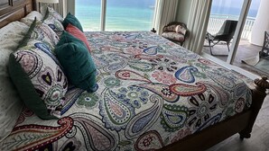 A bedroom with a large bed, a ceiling fan, and a view of the ocean through large windows. - Delicious 3BR-3BA Direct Gulf Front Condo (Panama City Beach)