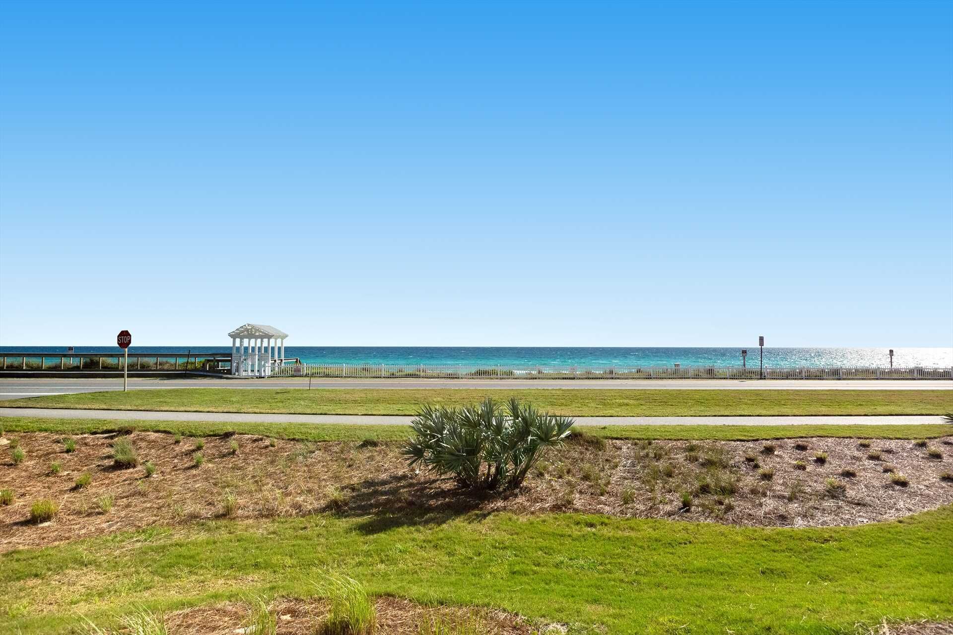 A coastal road with a stop sign, a gazebo, and a view of the ocean.
