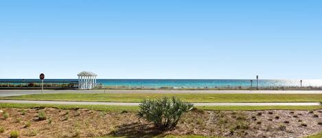 A coastal road with a stop sign, a gazebo, and a view of the ocean.