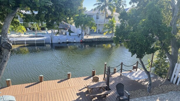 Eine Holzterrasse mit Liegestühlen und einem Pool.