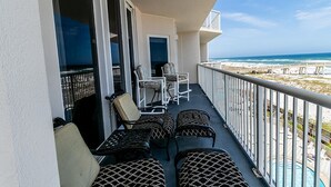 A balcony with outdoor furniture, a view of the beach, and a pool. - FREE Beach Chairs, GULF FRONT, Common Pool/Hot Tub, VIEWS!, Wrap around balcony (Navarre)