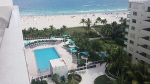 A resort with a swimming pool, beach, and palm trees. - SOBE ~ ART DECO DISTRICT ~ SOUTH BEACH ~ RITZ CARLTON       Condo on the Water (Miami Beach)