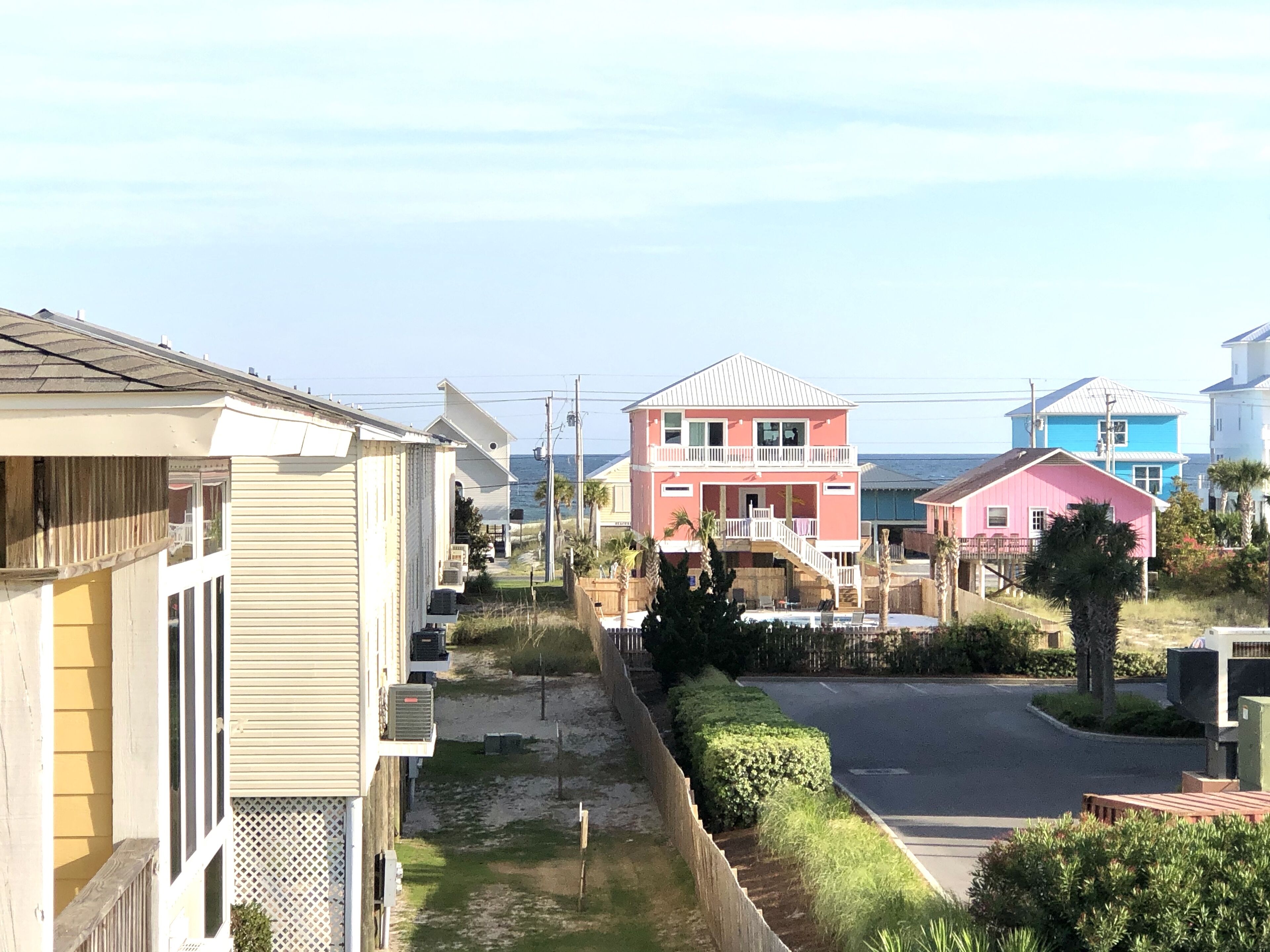 Una zona residenziale costiera con case, cielo sereno e vista sull'oceano.