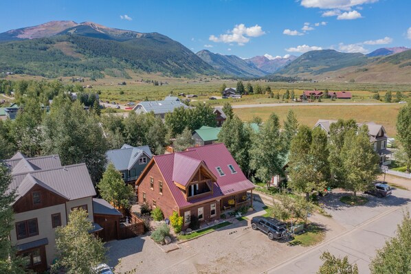 A residential area with houses, a driveway, and a mountain backdrop.