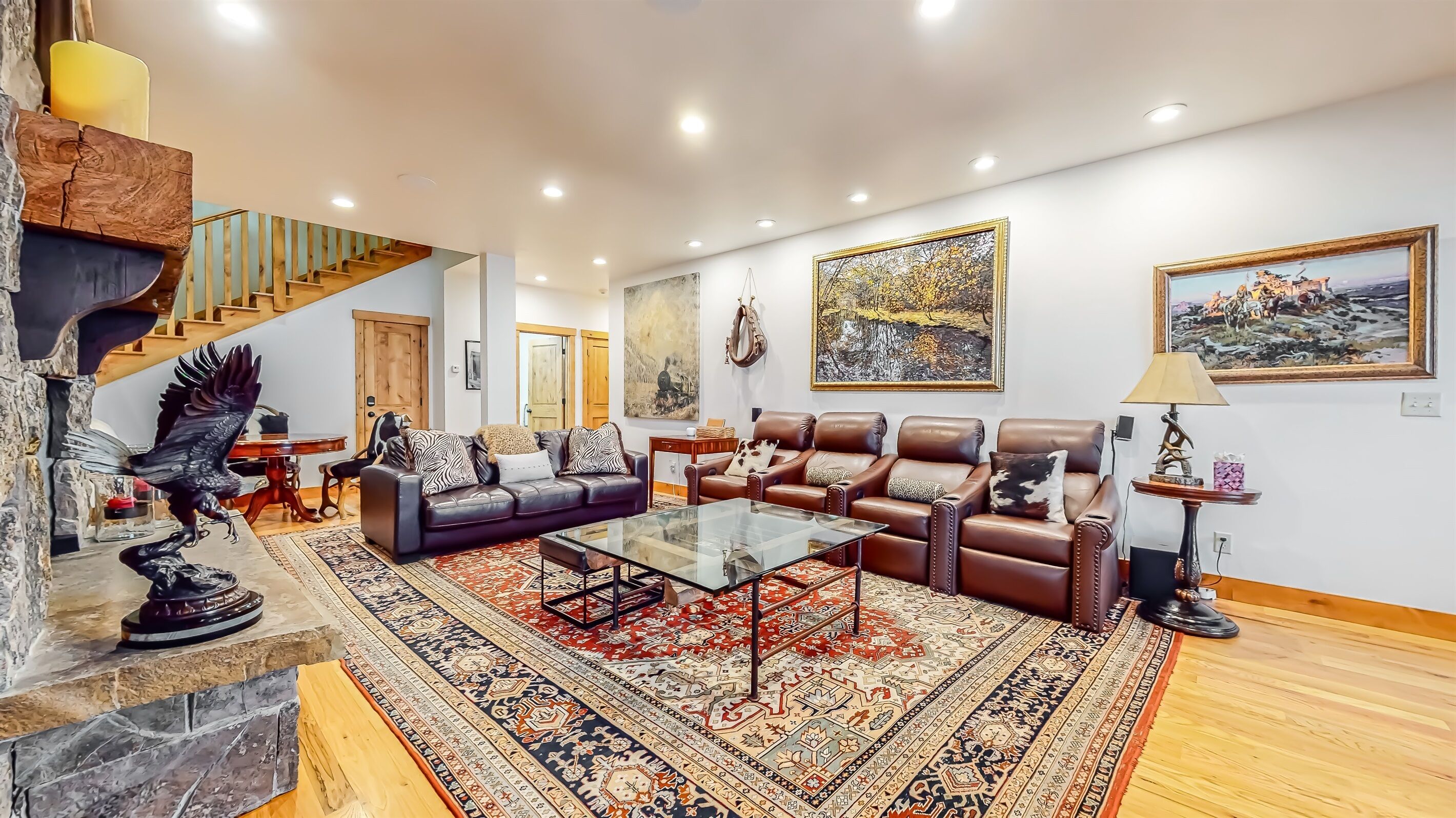A spacious living room with a large sofa set, a coffee table, and a patterned rug.