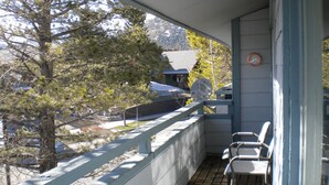A balcony with a view of a snowy mountain, a satellite dish, and a clock on the wall.