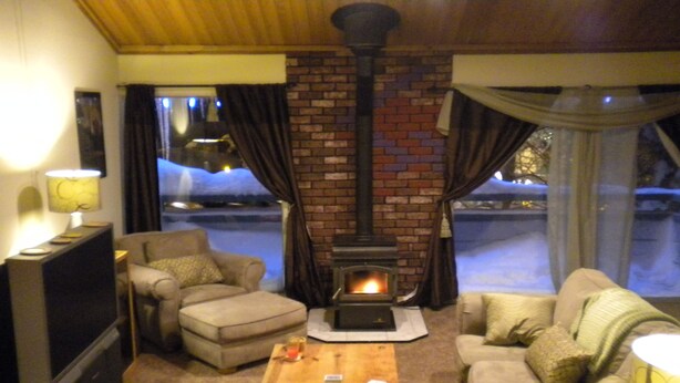 A cozy living room with a fireplace, comfortable seating, and a television.