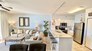 Relax in this open-plan living and dining area with a sofa set, coffee table, and dining bar.