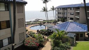 Ein Hotel mit Pool, Palmen und Meerblick.