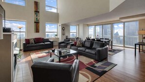 A spacious living room with a large window, a dining area, and a view of the city skyline. - 2-Story Penthouse Views, Fireplace, Pool, Gym (Chicago)