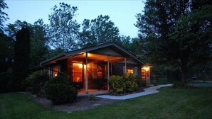 Einbungalow mit überdachter Veranda, Ziegelaußenwand und gepflegtem Rasen.