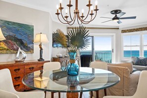 Relax in this stylish living room with a round table, comfortable chairs, and a stunning ocean view.