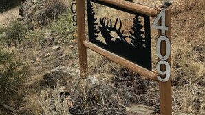 Un cartel con la inscripción 'Mountain Views' y el número '409', en un entorno natural con árboles y montañas al fondo.