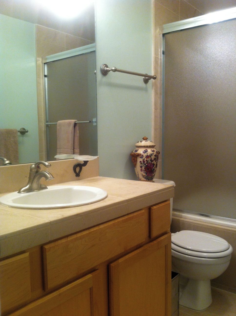 A bathroom with a sink, mirror, toilet, and shower.