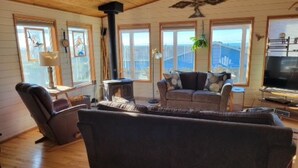 Ein gemütliches Wohnzimmer mit Kamin, einer Couch, einem Liegesessel und einem Fernseher.