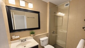 Een badkamer met een wastafel, toilet en douchecabine.