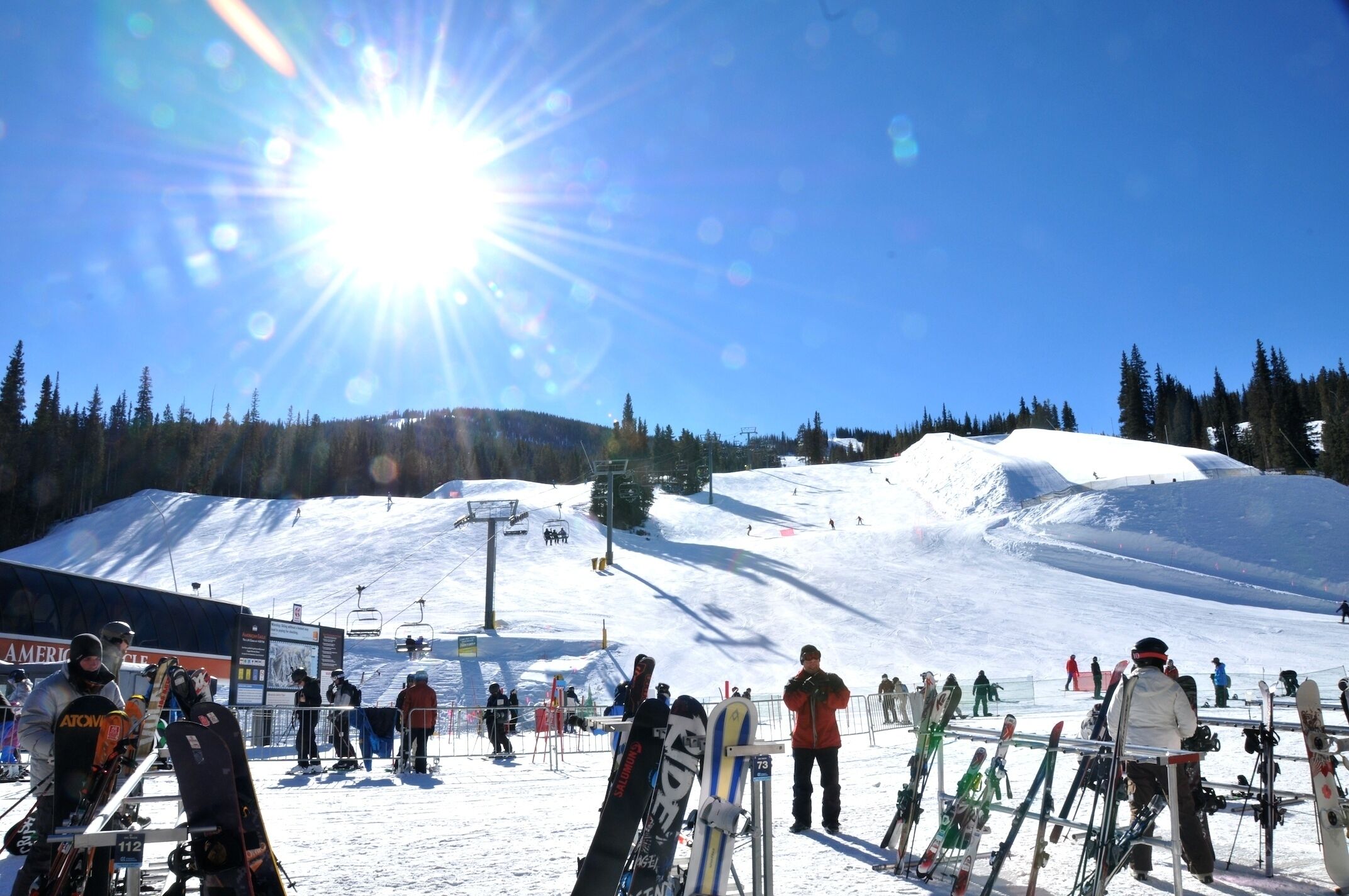 A ski resort with a ski lift, snow-covered slopes, and skiers.