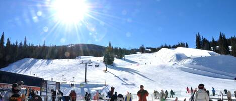 A ski resort with a ski lift, snow-covered slopes, and skiers.