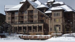 A multi-story hotel with balconies and a snow-covered roof.