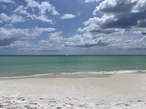 A beach with clear turquoise water and a sandy shore. - COZY, CHIC BEACH HOME 3BEDS/3 BATH, STEPS TO THE BEACH & ALL THE ACTION (Panama City Beach)