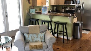 Une cuisine moderne avec des meubles en bois, un réfrigérateur en acier inoxydable et un coin bar.