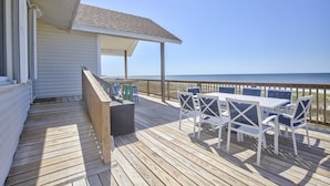 A wooden deck with a table and chairs, overlooking a beach. - 7 Bedroom Beach House with POOL!! Gulf Front and Bay Front (Alligator Point)