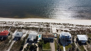 An aerial view of a coastal property with multiple buildings, a swimming pool, and a beach. - 7 Bedroom Beach House with POOL!! Gulf Front and Bay Front (Alligator Point)