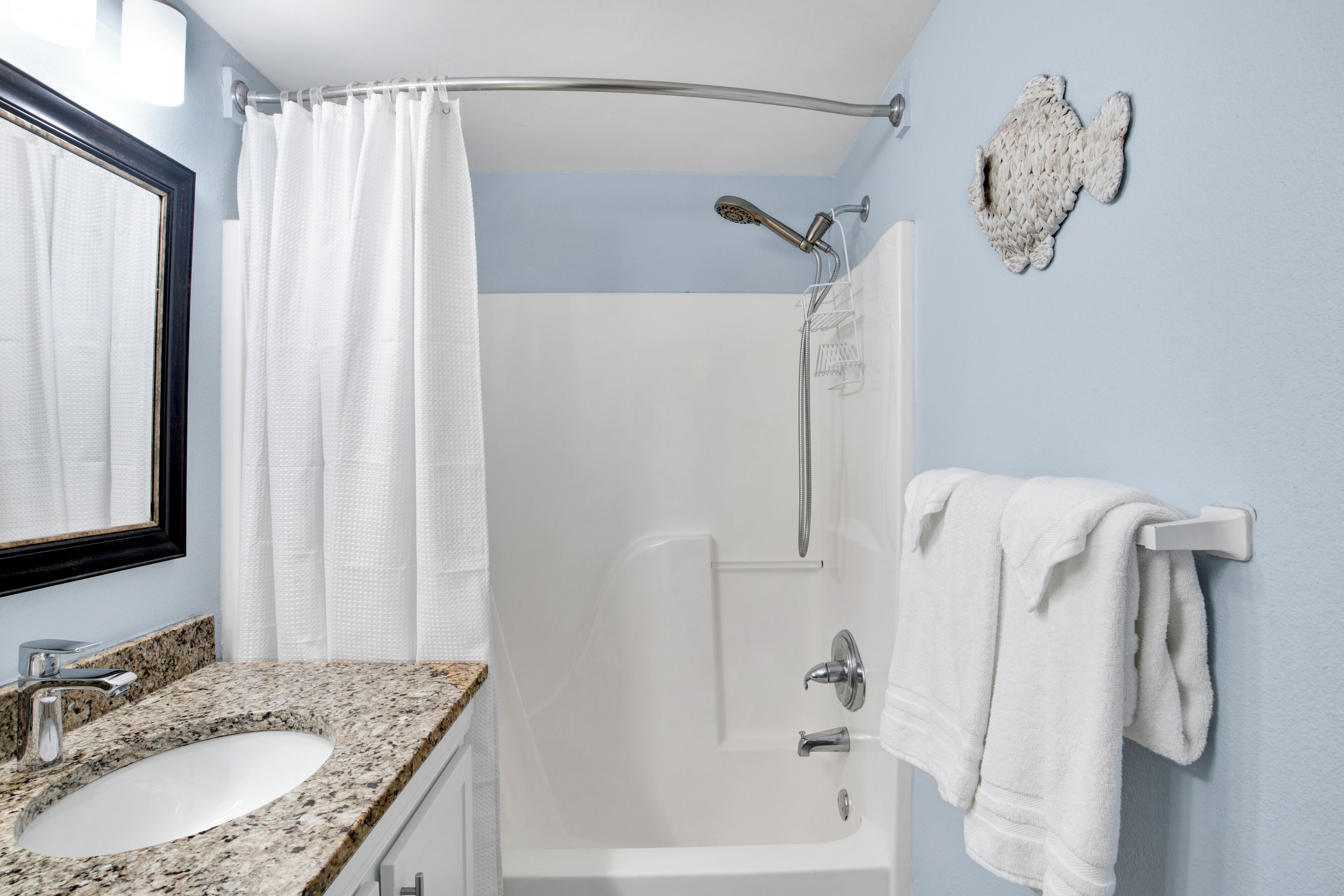 Ein Badezimmer mit Waschbecken, Dusche und Handtuchhalter.