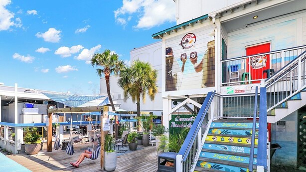 A hotel with a pool area, outdoor seating, and a staircase with colorful steps.