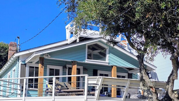 Une maison à deux étages avec un balcon, une véranda et un garage.