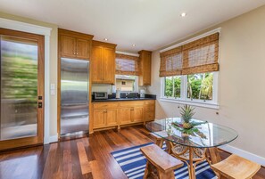 Enjoy meals at the glass dining table with a bench in this well-appointed kitchen.