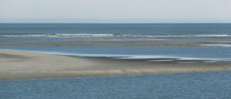 A beach with a wide sandy area and calm water.