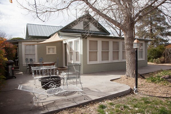 A house with a covered patio, outdoor seating, and a fire pit.