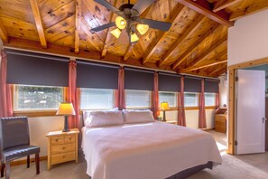 A bedroom with a large bed, two bedside tables with lamps, a chair, and a ceiling fan. - Large 4 bed, 2 bath luxury home, views, patios for up to 8 guests (Bisbee)