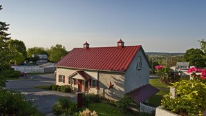 Ein eingeschossiges Haus mit rotem Dach, einer Steinaußenwand und einer kleinen Veranda.