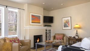 A living room with a fireplace, a television, and a sofa.