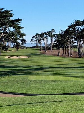 A golf course with a clear sky, green grass, and trees. - Monterey Peninsula Area  Seaside Guest House (Seaside)