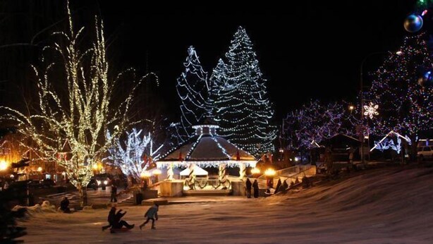 A snow-covered area with illuminated Christmas trees and a building with a traditional roof. - Mountain View Haus on Main - In the heart of "Bavaria" (Leavenworth)