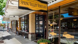 L’extérieur du domaine viticole de Spring Valley, avec une enseigne bien visible, une façade en briques et de grandes fenêtres.