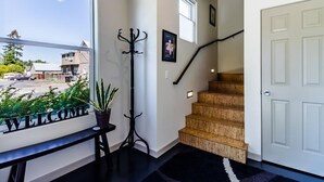 A staircase leading to a door, a coat rack, a welcome sign, and a window with a view of the outside. - Urban Oasis in Downtown Walla Walla.  Walk to Wine, Restaurants and More! (Walla Walla)