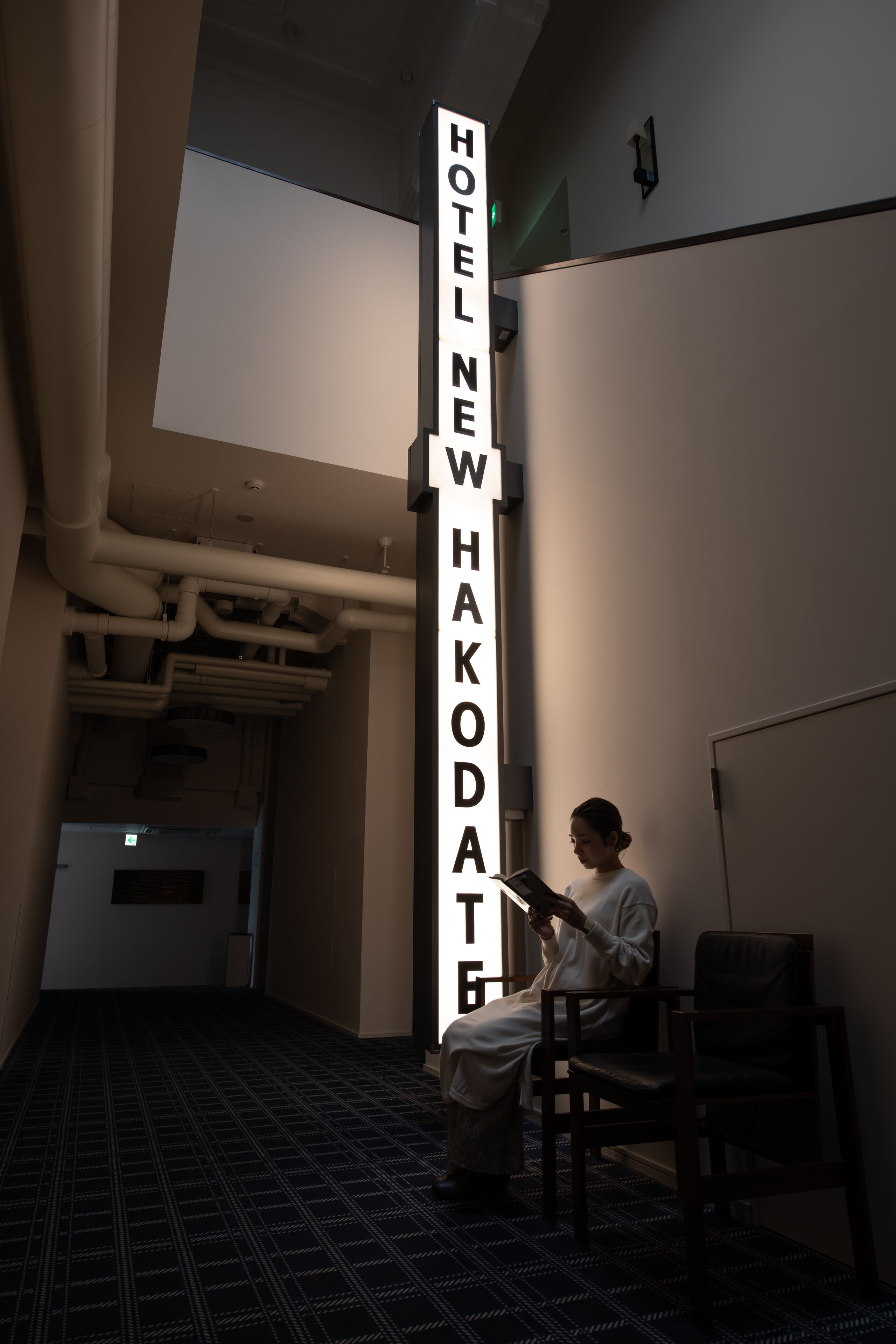 A hotel corridor with a vertical sign reading "HOTEL NEW WHAKODATE".