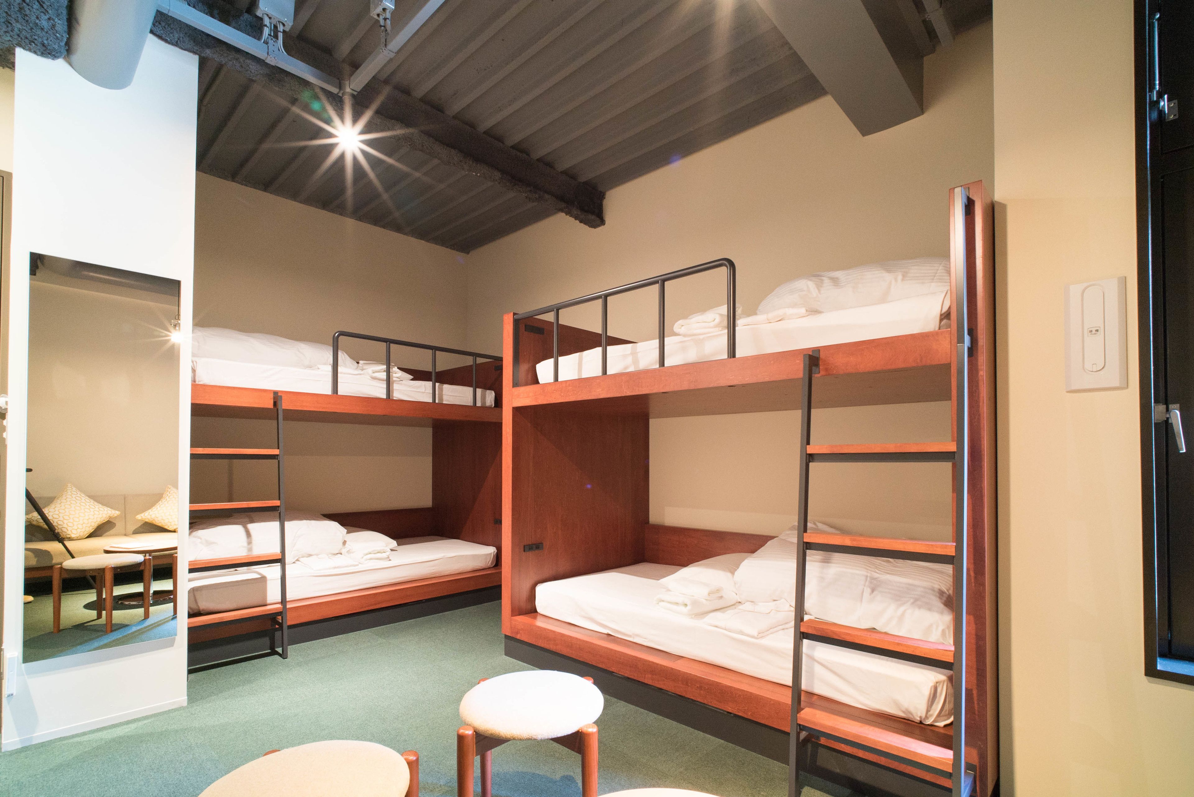 Una habitació de dormitori amb literes, una taula petita i una cadira.