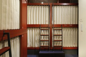 Una habitación con literas, una escalera y cortinas.