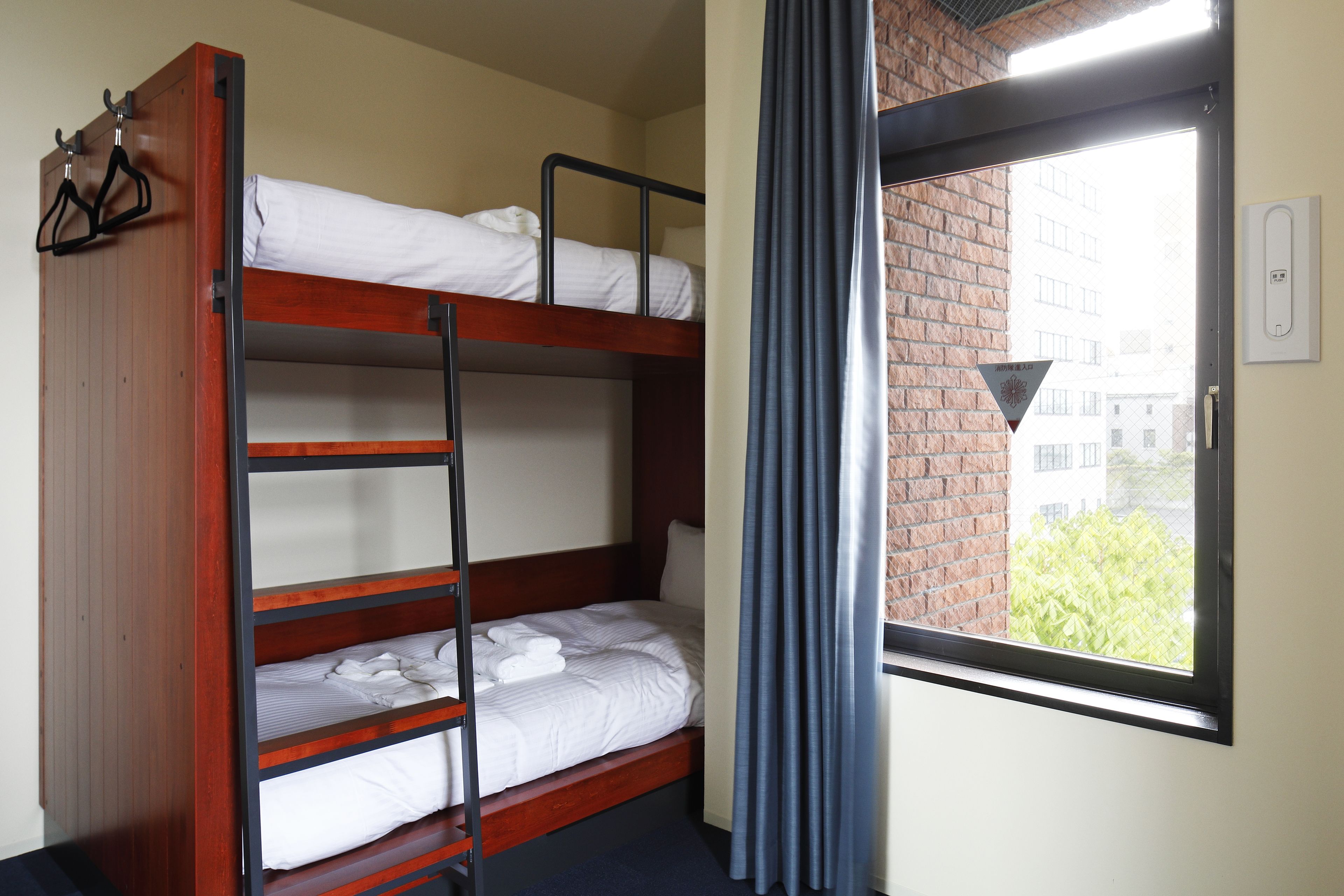A bunk bed room with a window and curtains.