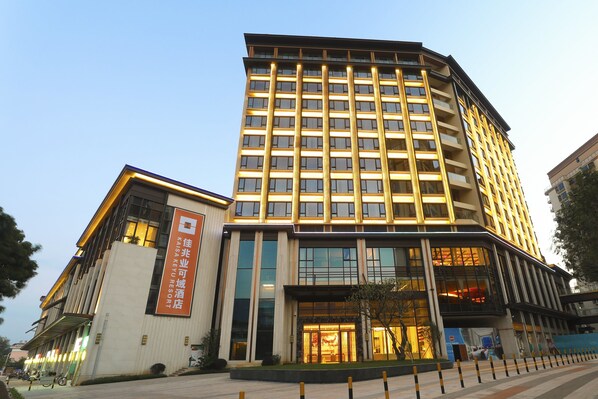 A modern hotel with a prominent entrance, large windows, and a vertical light strip on the facade. - Kare Prime Hotel Dapeng Shenzhen (Shenzhen)