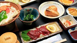 A variety of Japanese dishes including sushi, sashimi, and tempura, served on a black table. - Oogiyama Ryokan (Fujikawaguchiko)