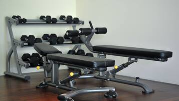 A gym with a bench and dumbbells.