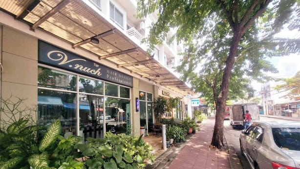 Une devanture de magasin avec une enseigne indiquant : « V. Nuck, coiffure professionnelle ».