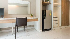Une cuisine moderne dotée d’un réfrigérateur encastré, d’un coin repas avec une chaise et d’un meuble en bois avec des étagères.